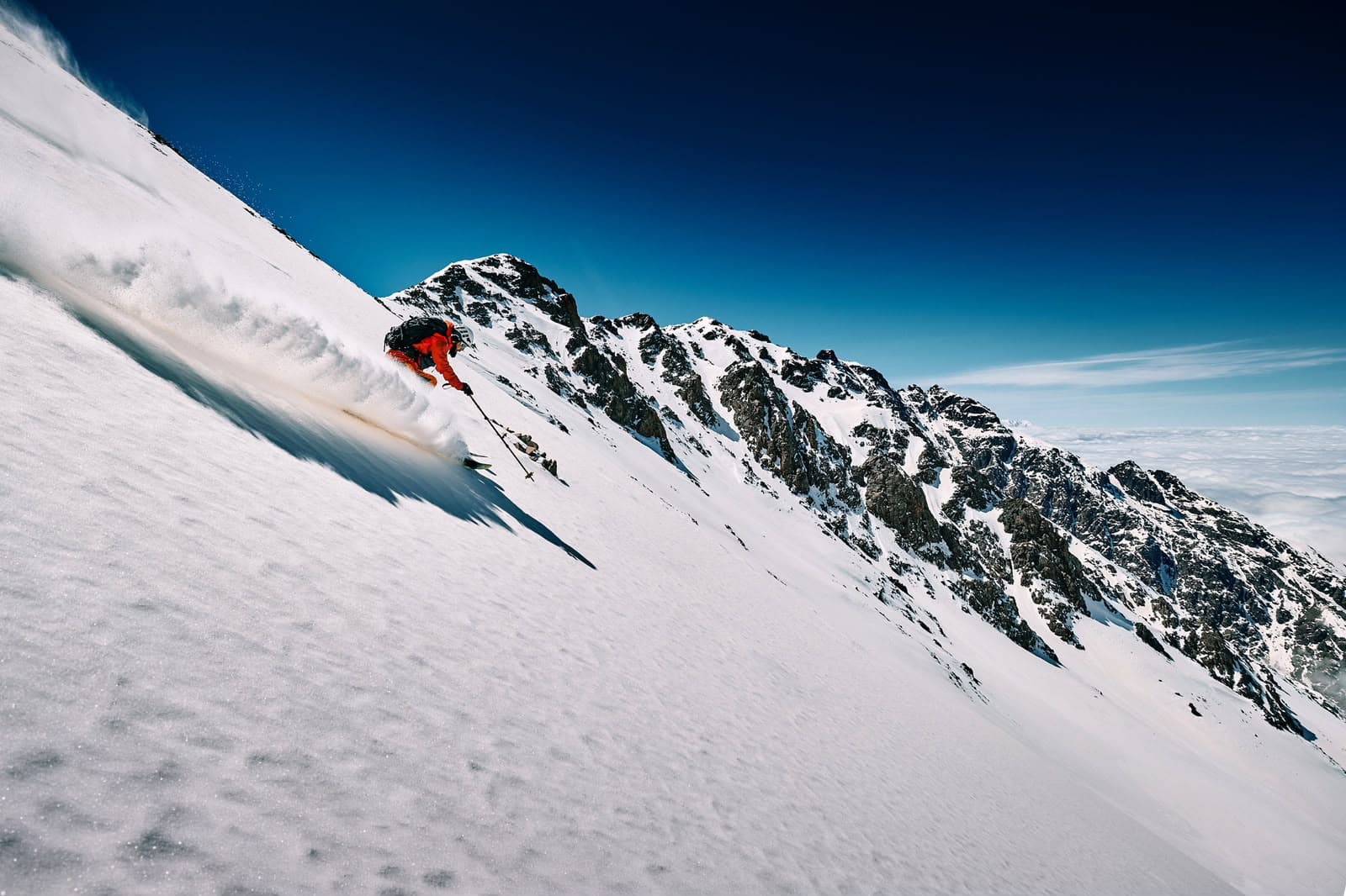 A skier descending a snow-covered mountain slope